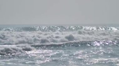 Powerful and rapid splash of shining waves in the sea on a summer day.