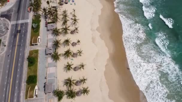Légi kilátás az útra és fenséges fehér homokos strand szörf hullámok ecset a tengerparton egy napsütéses napon. — Stock videók