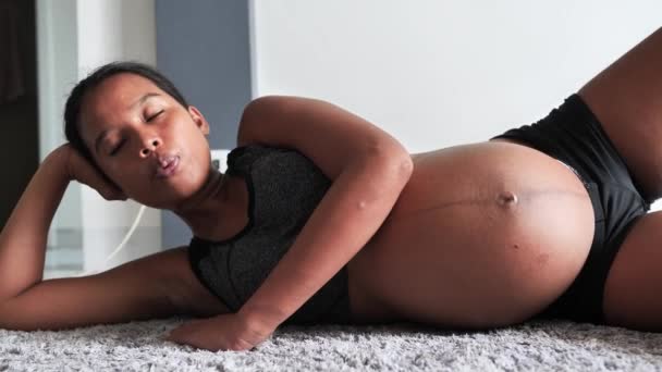 Genç hamile bir kadının evde bacak ve nefes egzersizi yapmasına yakın çekim.. — Stok video