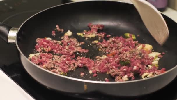 在电炉上用不粘的平底锅煮碎牛肉. — 图库视频影像