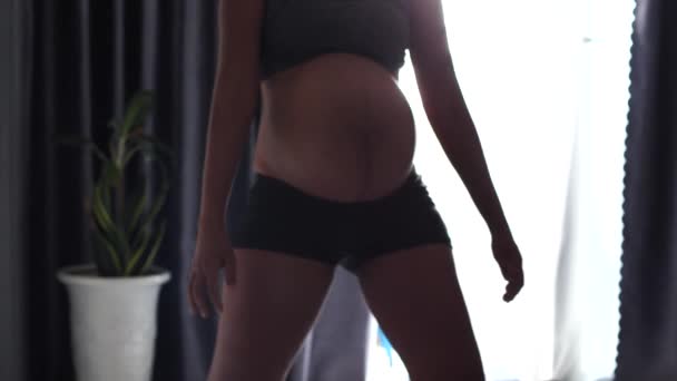 Heureuse jeune femme enceinte dansant et faisant de l'exercice squat intérieur. — Video