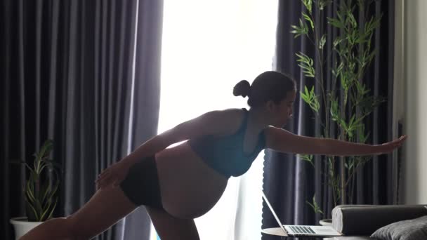 Donna incinta con pancia enorme facendo yoga posa bilanciamento su una singola gamba. — Video Stock