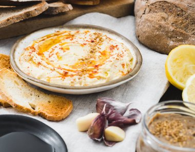 İçinde malzemeler olan sağlıklı ev yapımı kremalı humus. Yan görüş. Nohut fasulyesinden yapılmış Akdeniz yemeği