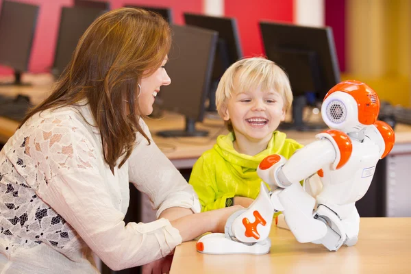 Female teacher programming robot with child — Stock Photo, Image