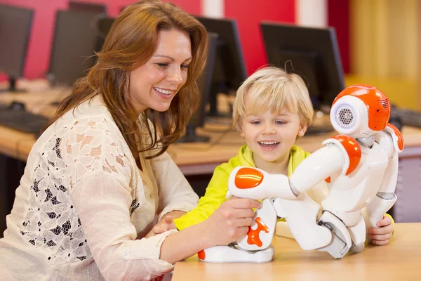 Female teacher programming robot with chil — Stock Photo, Image