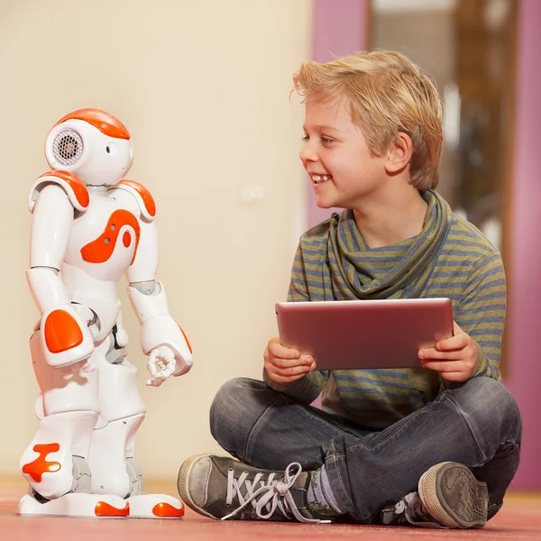 Kind spelen en leren met robot Stockfoto