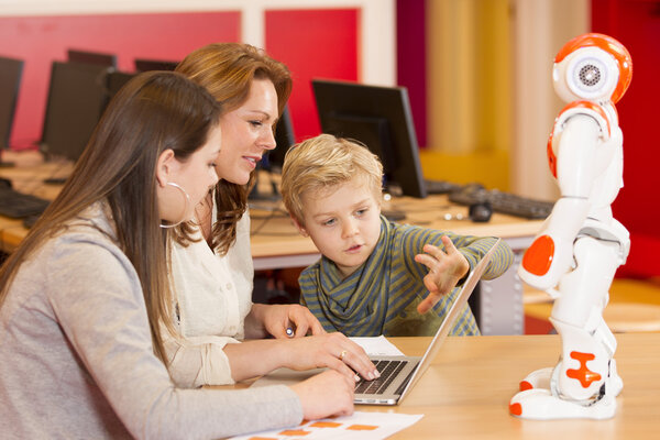 Female teacher programming robot with children Stock Image