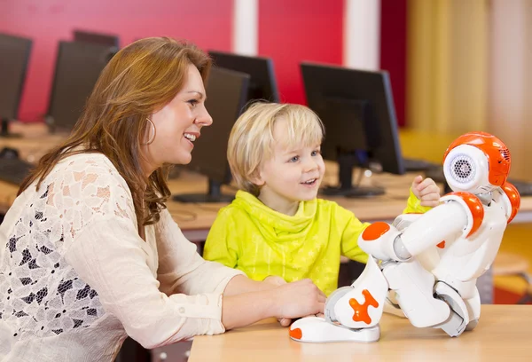 Female teacher programming robot with child — Stock Photo, Image