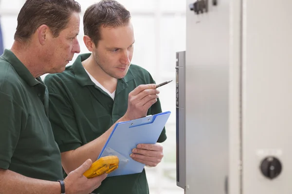 Dos técnicos masculinos reparando maquinaria agrícola — Foto de Stock