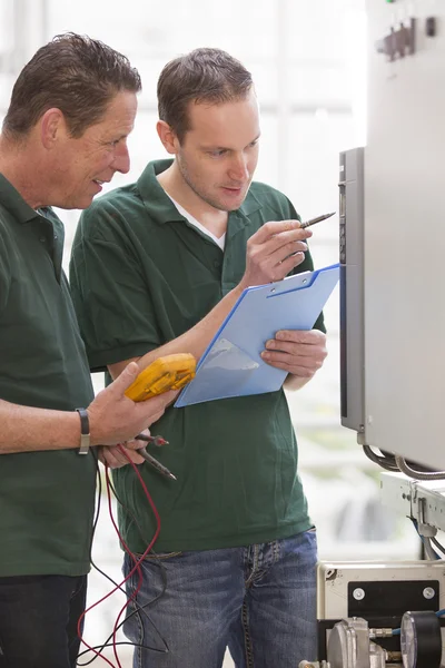 Two male technicians repairing agriculture machinery — Stock Photo, Image