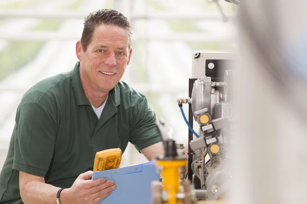 Male technician repairing agriculture machinery — Stock Photo, Image