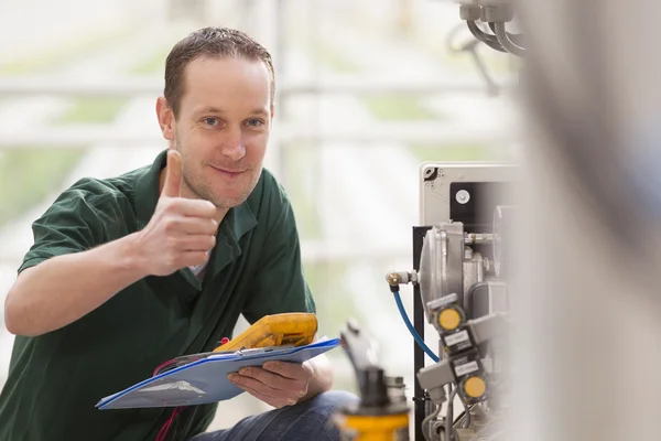 Male technician repairing agriculture machinery — Stock Photo, Image