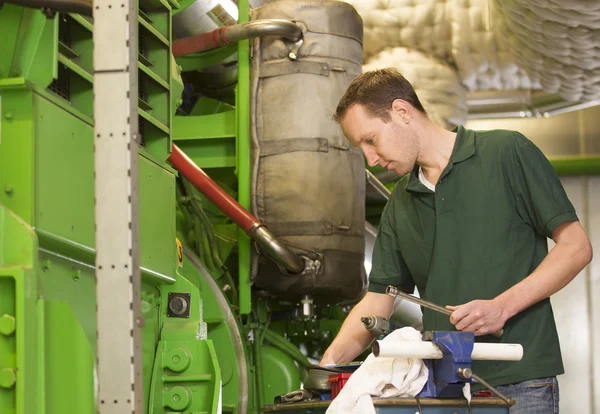 Male technician repairing agriculture machinery — Stock Photo, Image