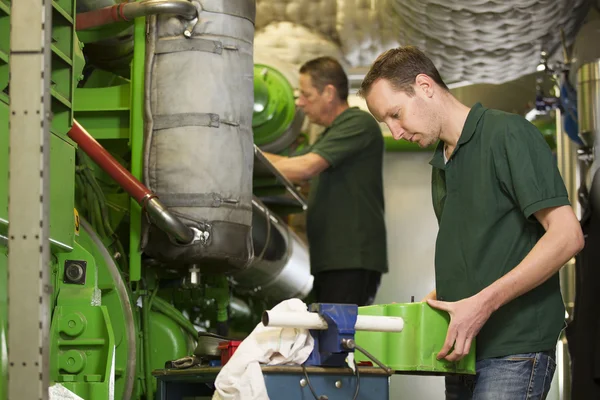 Twee mannelijke technicus reparatie landbouw machines Stockfoto