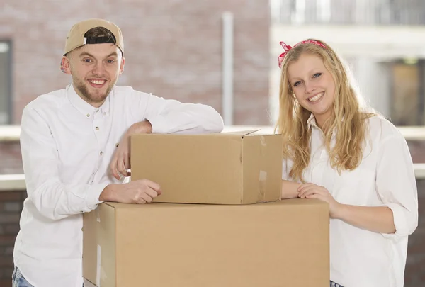 Jovem casal feliz se mudando em sua nova casa — Fotografia de Stock