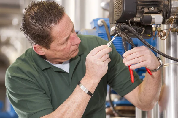 Male technician repairing agriculture machinery — Stock Photo, Image