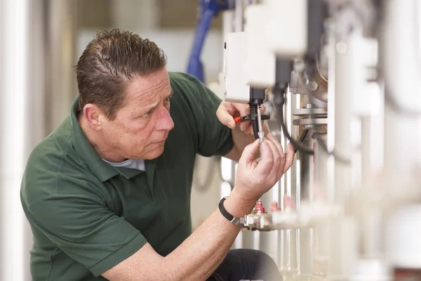 Male technician repairing agriculture machinery — Stock Photo, Image