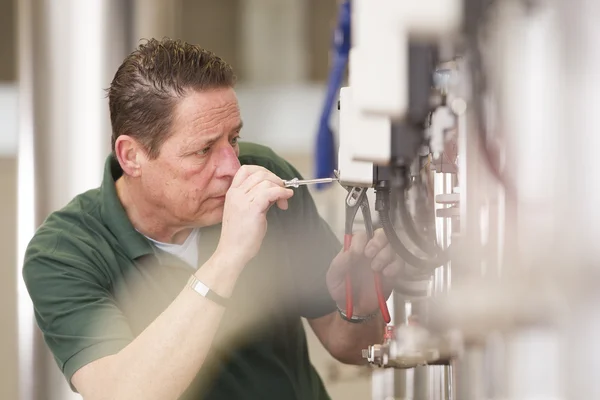 Male technician repairing agriculture machinery — Stock Photo, Image