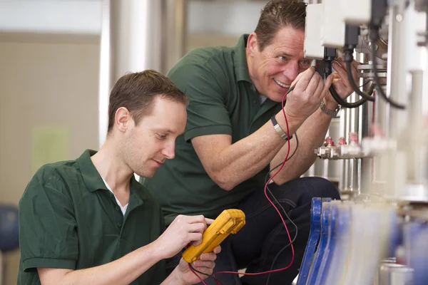 Dos técnicos masculinos reparando maquinadora agrícola —  Fotos de Stock