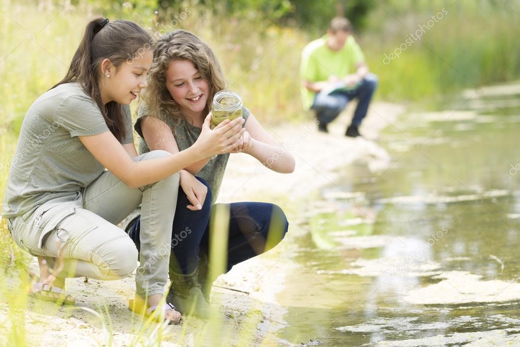 Pretty young girls having outdoor science lesson  exploring natu