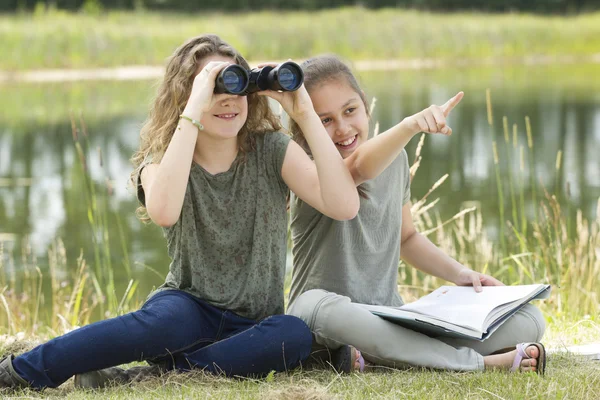 Ganska ung flicka att utforska miljön med en kikare — Stockfoto