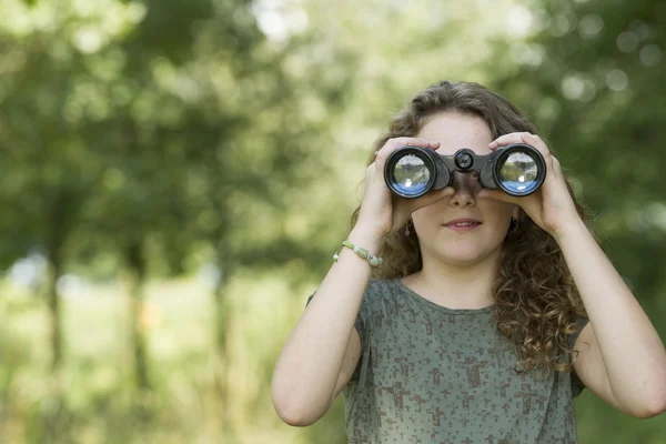 Linda joven explorando el medio ambiente con un binocular —  Fotos de Stock