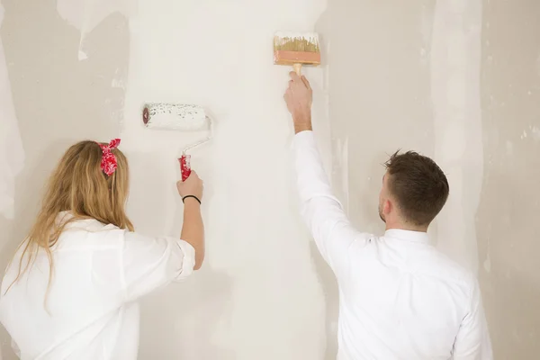 Happy young couple doing a odd-job in their new house — Stock Photo, Image