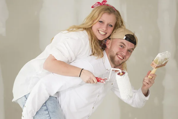 Feliz jovem casal fazendo um estranho-trabalho em sua nova casa — Fotografia de Stock