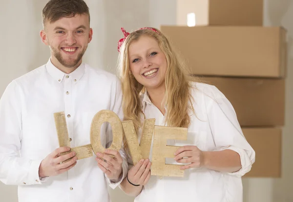 Glada unga par som flyttar i sitt nya hem — Stockfoto