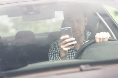 Araba sürüş sırasında cep telefonu kullanan adam