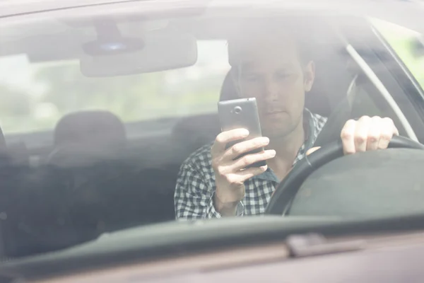 Homem usando telefone celular durante a condução do carro — Fotografia de Stock