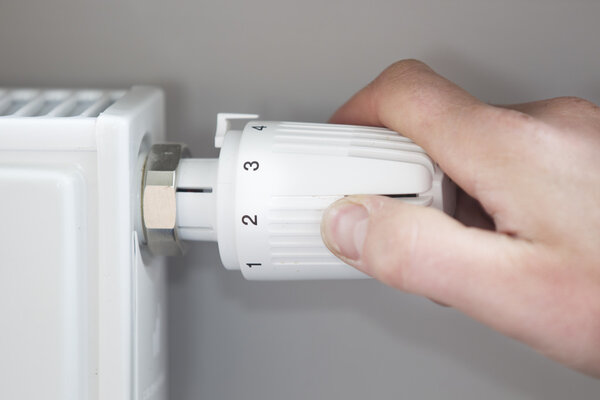 Hand Adjusting Thermostat At Home