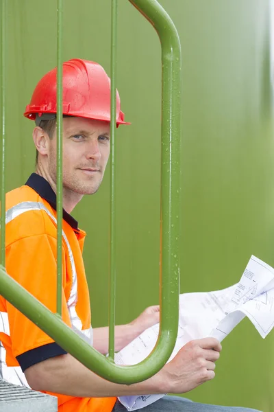 Arquitecto Holding Blueprint en el parque de tanques de almacenamiento — Foto de Stock