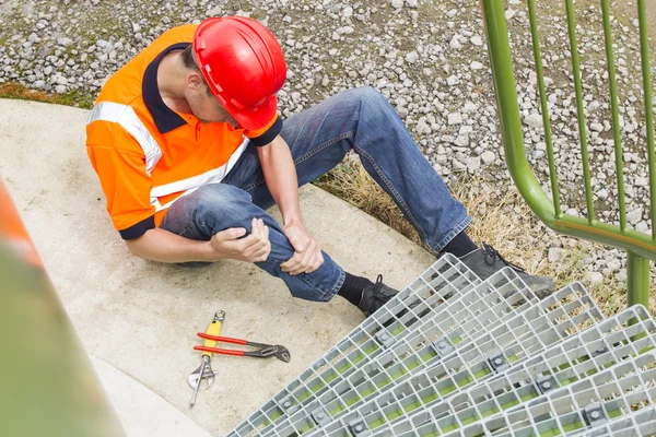 Arbeidstaker som lider av bensmerter ved lagringstanketrinn – stockfoto