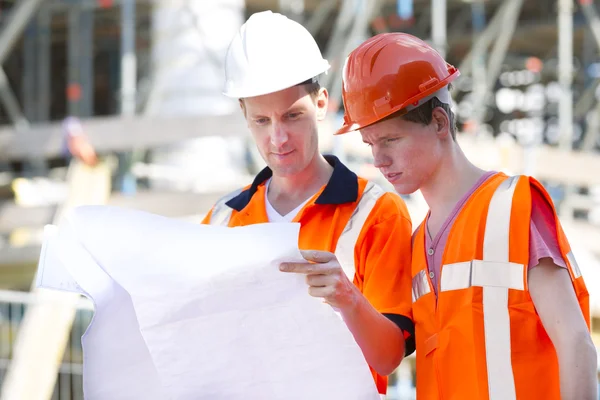 Architekten tragen Schutzkleidung bei der Analyse des Bauplans — Stockfoto