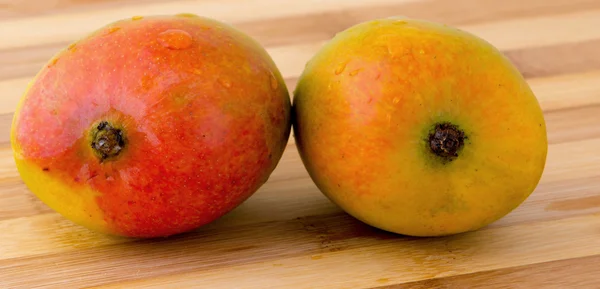 Dos mango sobre tabla de tallar — Foto de Stock