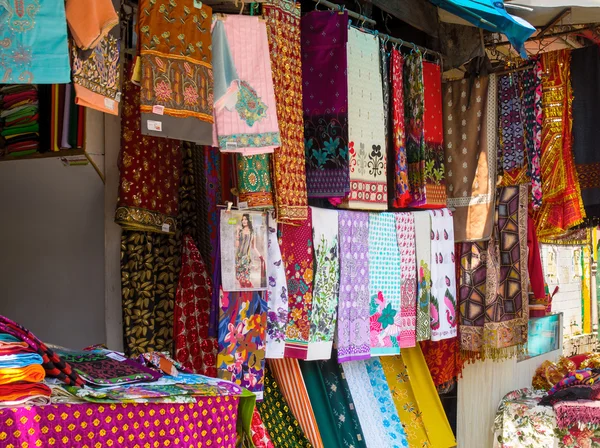 Colorful fabrics and shawls at a market stall — Stock Photo, Image