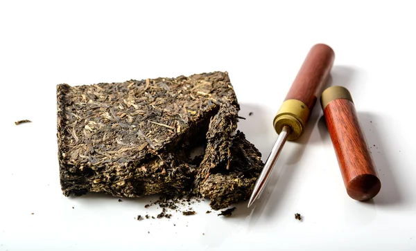 Tè cinese pu-erh nero con coltello speciale su sfondo bianco — Foto Stock