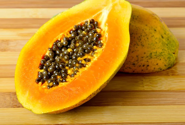 In Scheiben geschnittene frische Papaya auf Holzgrund — Stockfoto