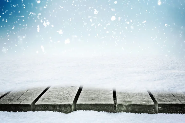 Mesa de madeira no snowdrift e neve folling sobre o céu de inverno — Fotografia de Stock