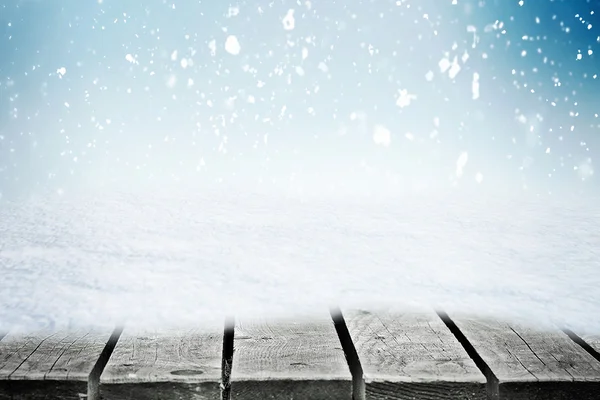 Mesa de madeira no snowdrift e neve folling sobre o céu de inverno — Fotografia de Stock