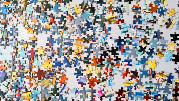 Kolor puzzle jest na białym stole. — Zdjęcie stockowe