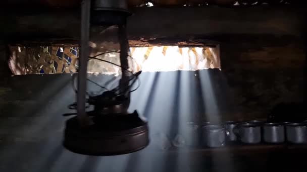 Une mare-réservoir en bois dans laquelle brûle une lampe au kérosène. La lumière de la fenêtre pénètre dans la pièce. — Video