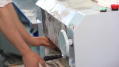 Hamur ürünleri üretimi. Hamuru yuvarlama makinesinin üzerine yuvarlama işlemi