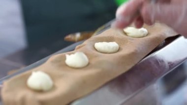 Hamur tatlısı yapma süreci. Dolguyu koy ve özel ekipmanların yardımıyla hamur işi yap.