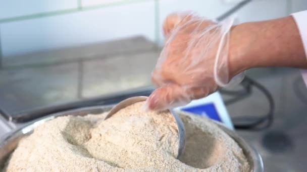 Close-up de chef derramando farinha de colher em tigela misturador elétrico. Trabalho de pastelaria. massa de farinha de amassar para pão ou massa. — Vídeo de Stock