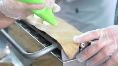 Hamur tatlısı yapma süreci. Dolguyu koy ve özel ekipmanların yardımıyla hamur işi yap.