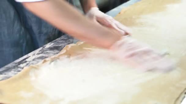 Fechar as mãos dos padeiros cobrir a massa com farinha de pão. — Vídeo de Stock