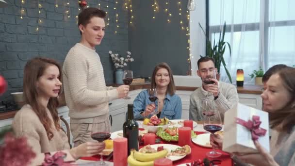 Vrienden aan tafel geven geschenken. Jongeren vieren feest. Een feestje.. — Stockvideo