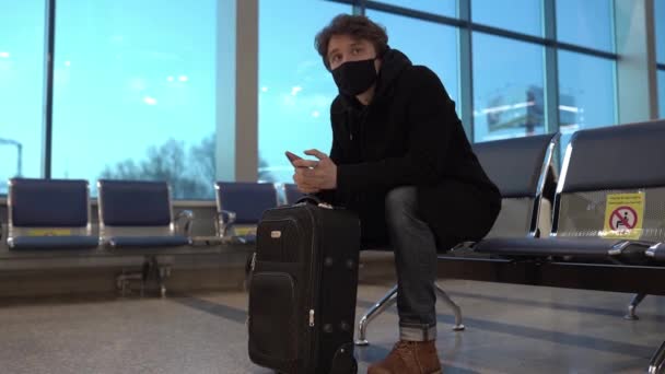 El hombre con máscara médica se sienta en el asiento de distancia social con marcas de advertencia. Viajando en coronavirus pandémico. Precauciones preventivas de seguridad para la salud. — Vídeo de stock